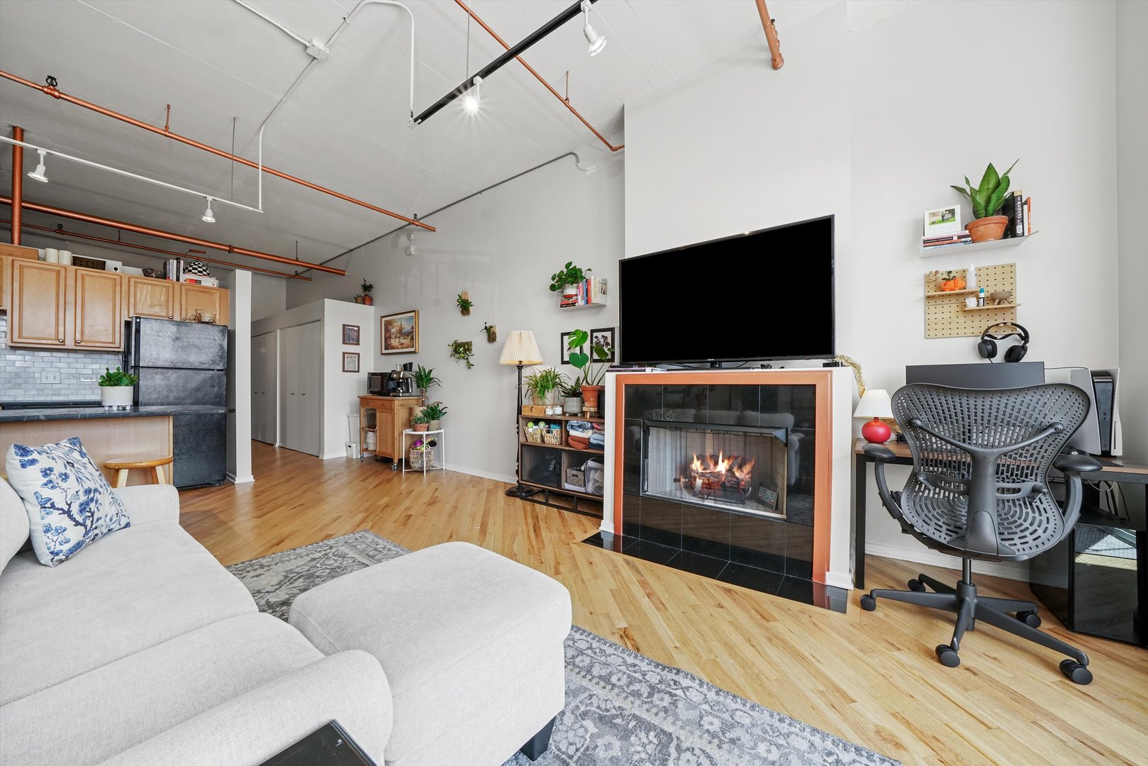500 South Clinton Street, Unit 424 Chicago, IL 60607 - Photo 5 of 29 a living room with furniture a flat screen tv and a fireplace