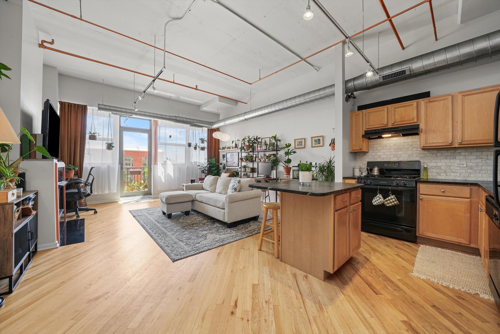 500 South Clinton Street, Unit 424 Chicago, IL 60607 - Photo 6 of 29 a kitchen with stainless steel appliances granite countertop a stove a sink dishwasher and a refrigerator with wooden floor