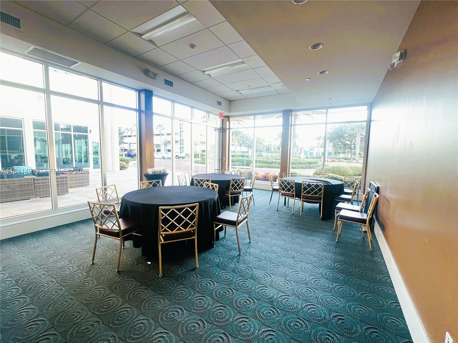 231 Riverside Drive, Unit 1210 Daytona Beach, FL 32117 - Photo 60 of 70 a view of a dining room with furniture large windows and wooden floor
