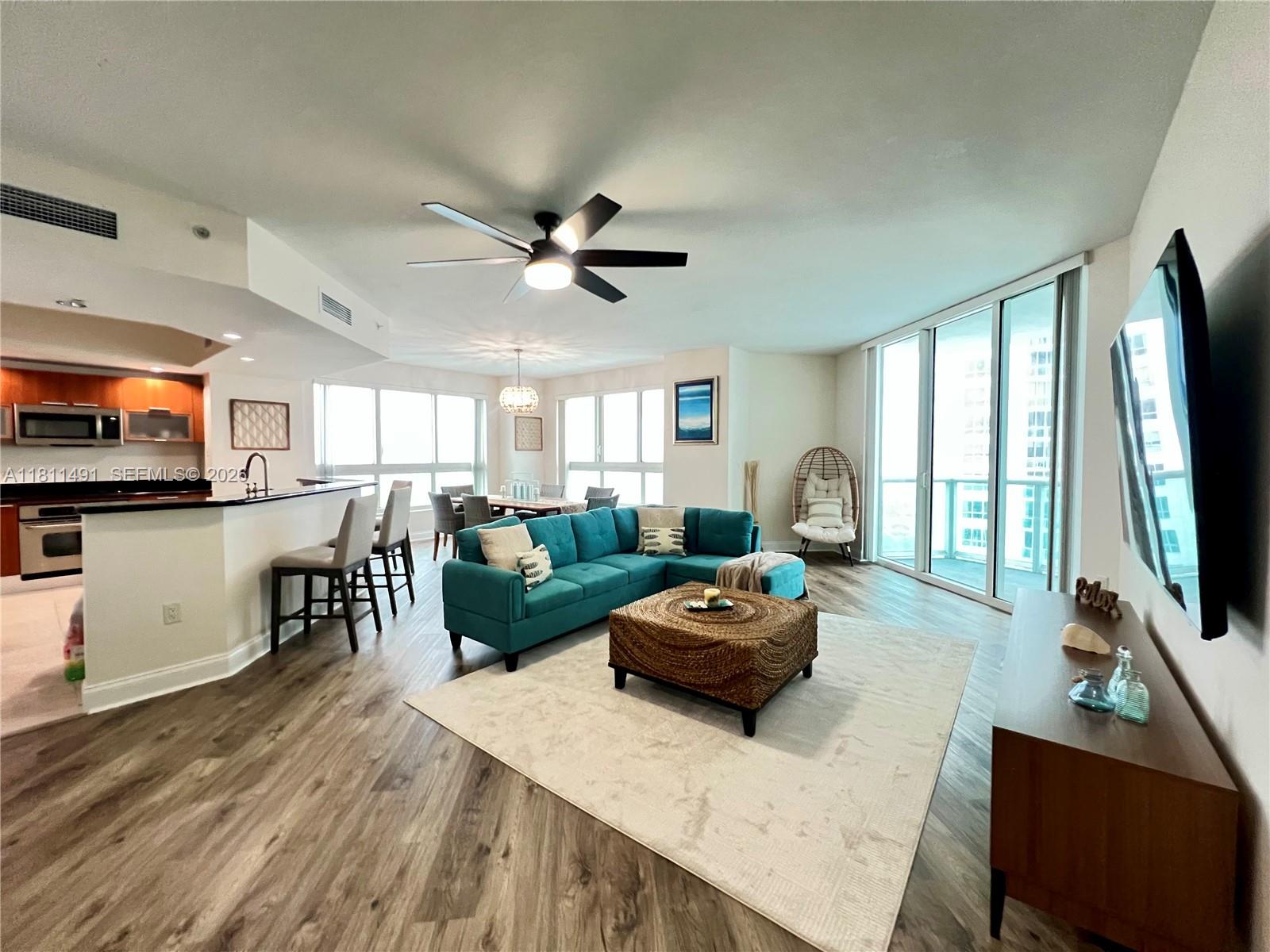 231 Riverside Drive, Unit 1210 Daytona Beach, FL 32117 - Photo 6 of 70 a living room with furniture a flat screen tv and a large window