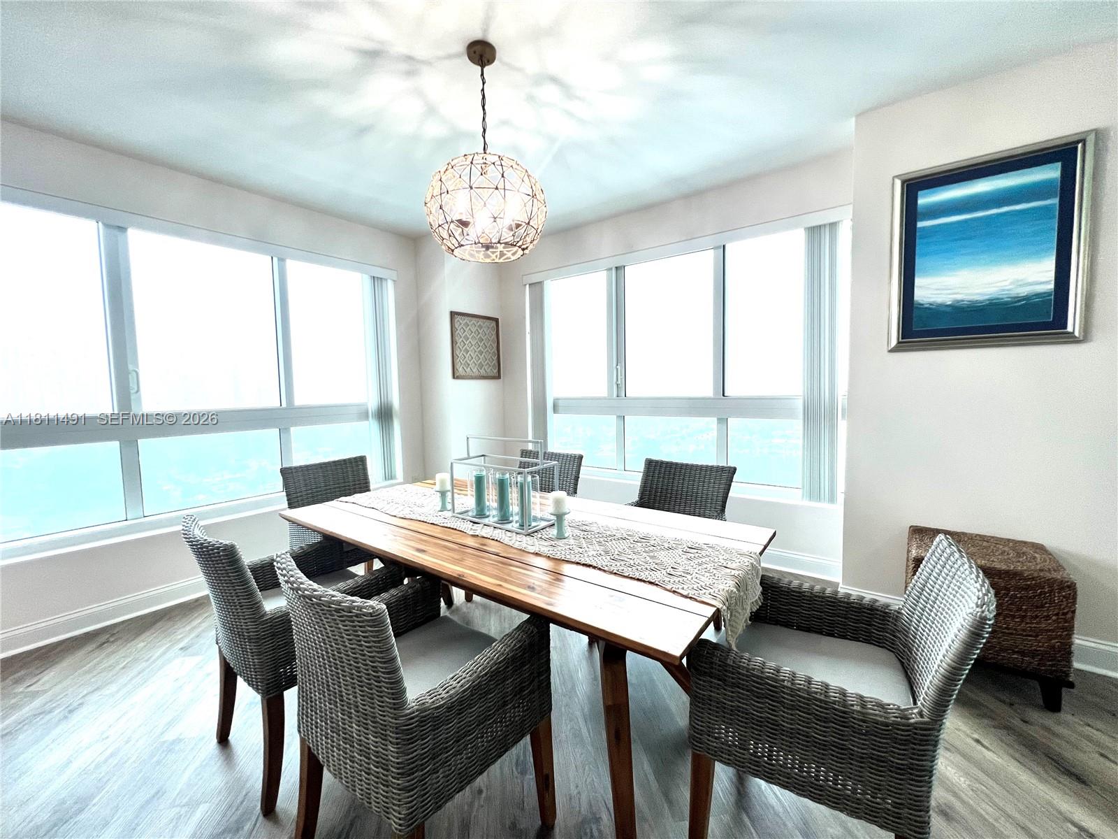 231 Riverside Drive, Unit 1210 Daytona Beach, FL 32117 - Photo 9 of 70 a view of a dining room with furniture a chandelier and wooden floor