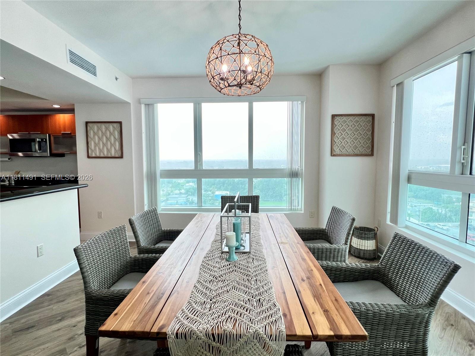 231 Riverside Drive, Unit 1210 Daytona Beach, FL 32117 - Photo 10 of 70 a view of a dining room with furniture wooden floor and a chandelier