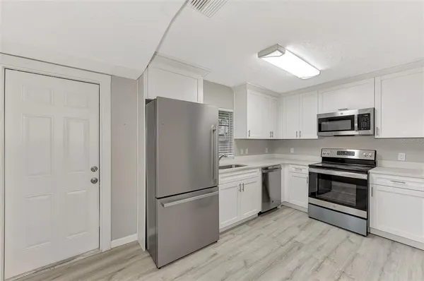 a kitchen with stainless steel appliances a refrigerator sink and microwave