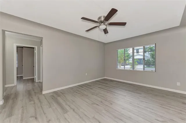 a view of a big room with wooden floor and windows