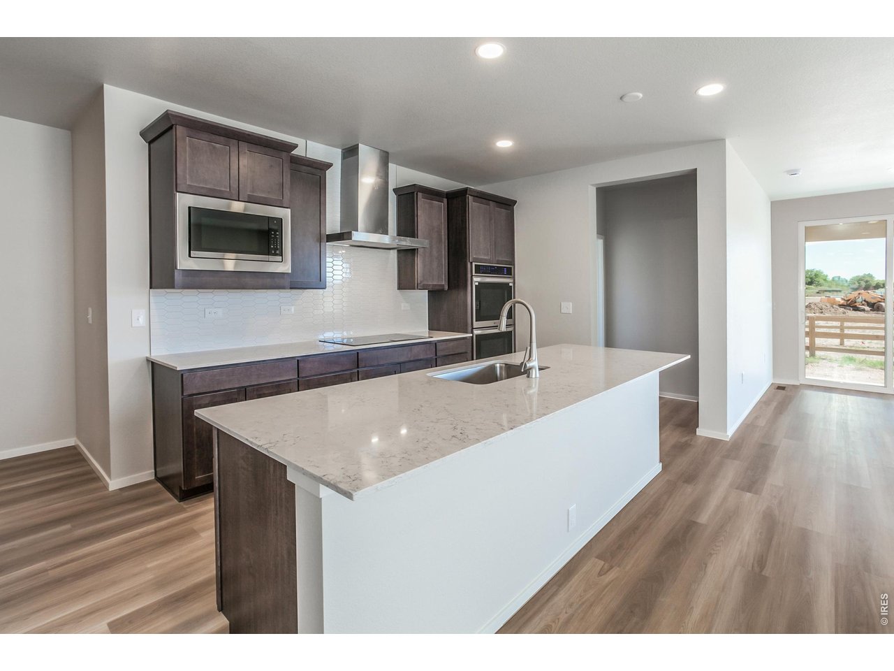 792 Chatter Road Windsor, CO 80550 - Photo 17 of 49 a view of kitchen with stainless steel appliances granite countertop a sink a microwave counter space and wooden floor