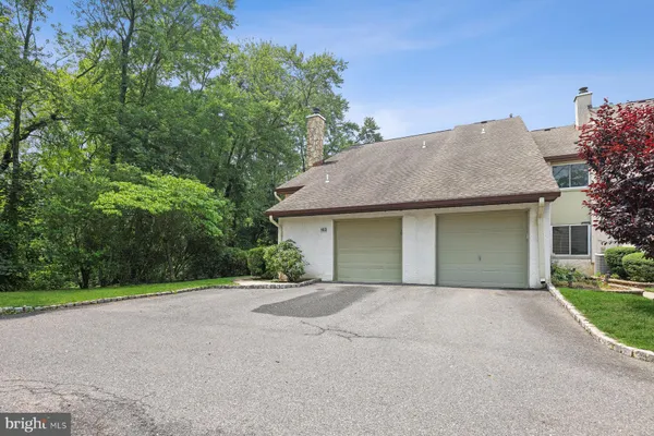 a front view of a house with yard and trees