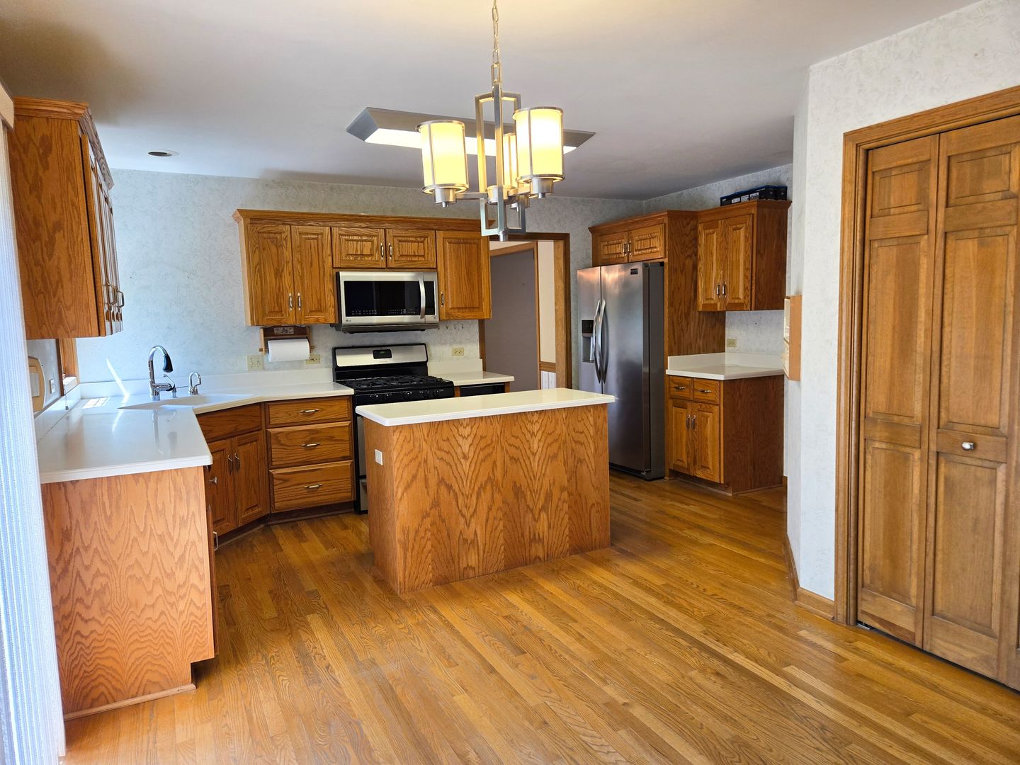 2286 Brookside Lane Aurora, IL 60502 - Photo 6 of 32 a kitchen with stainless steel appliances granite countertop a stove top oven a sink dishwasher a refrigerator and a dining table with wooden floor