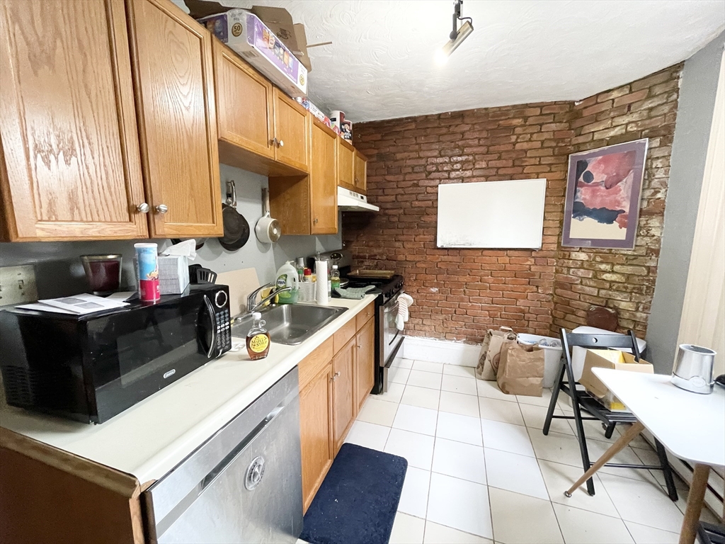 74 Hammond Street, Unit 2 Boston, MA 02120 - Photo 2 of 10 a kitchen with stainless steel appliances kitchen island granite countertop a sink and cabinets