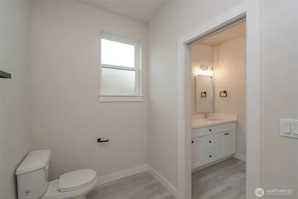 a bathroom with a granite countertop toilet a sink and a mirror