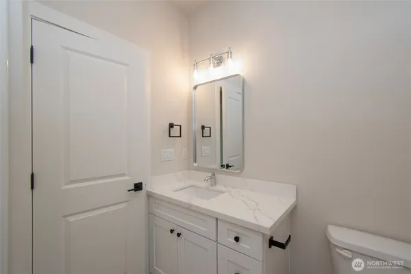 a bathroom with a sink a light fixture and a toilet