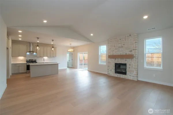 a view of an empty room and kitchen view