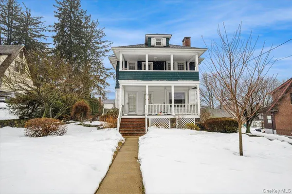 a front view of a building with a yard covered in snow
