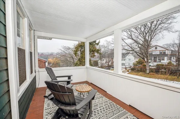 a balcony with chairs and wooden floor