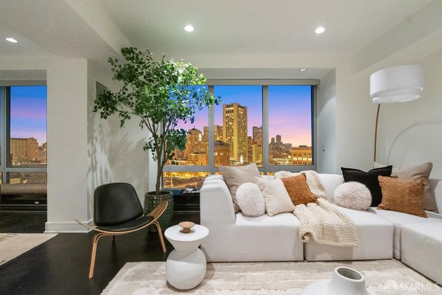 a living room with furniture a lamp and a potted plant