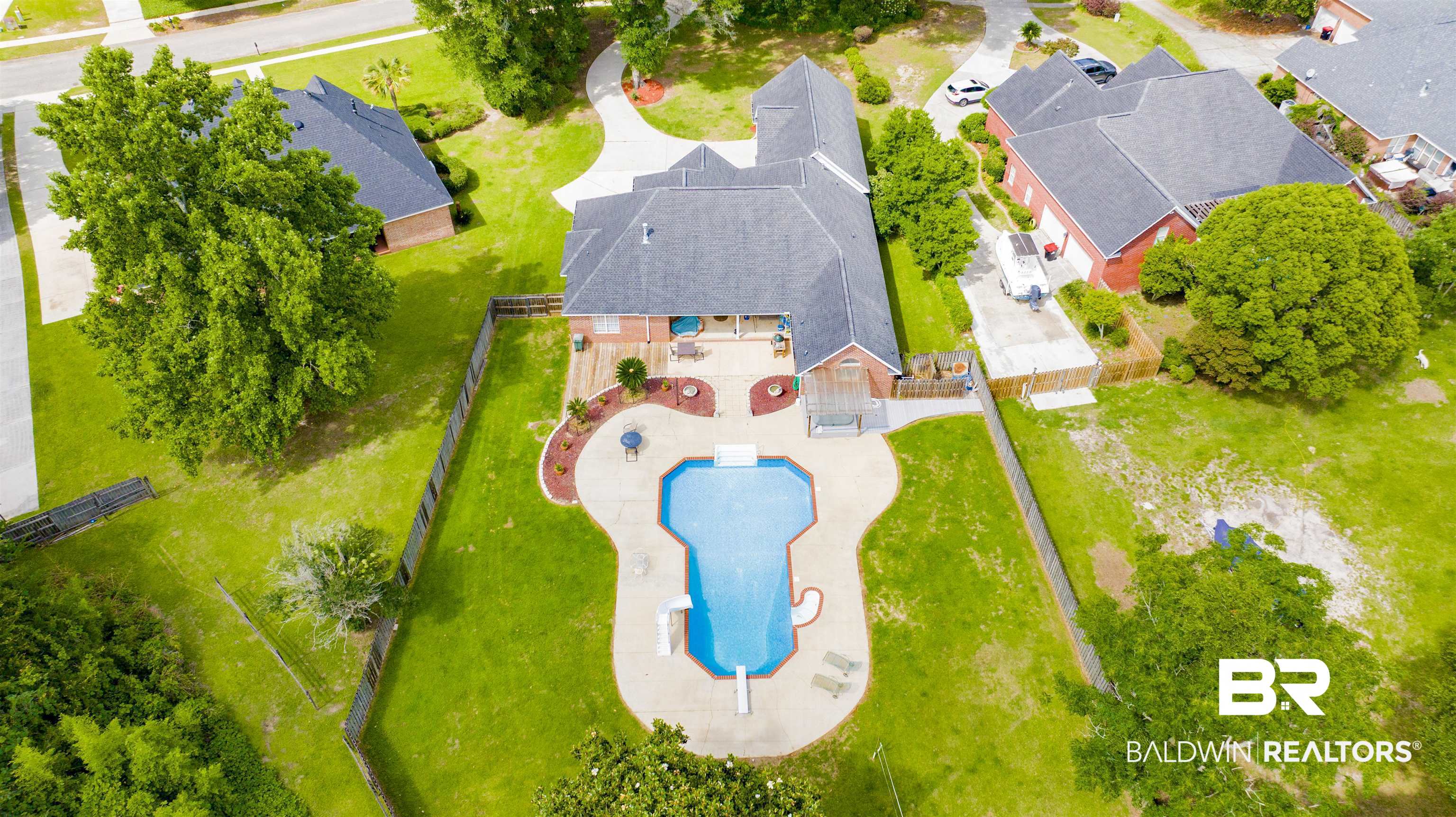 8847 Dawes Lake Road South Mobile, AL 36619 - Photo 38 of 47 Expansive backyard featuring a custom-shaped swimming pool with concrete surround, mature green lawn, and privacy fencing