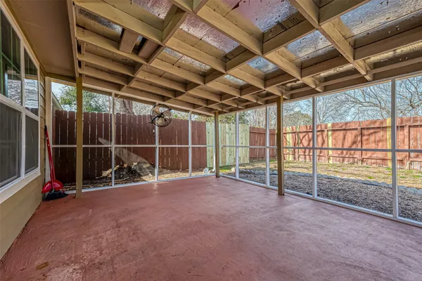 a view of empty room with wooden floor and windows