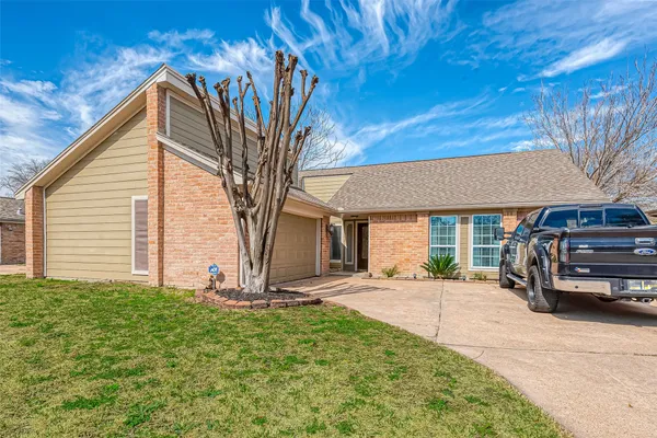 a view of a house with a large tree and a yard