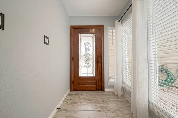 a view of an empty room with wooden floor and fireplace