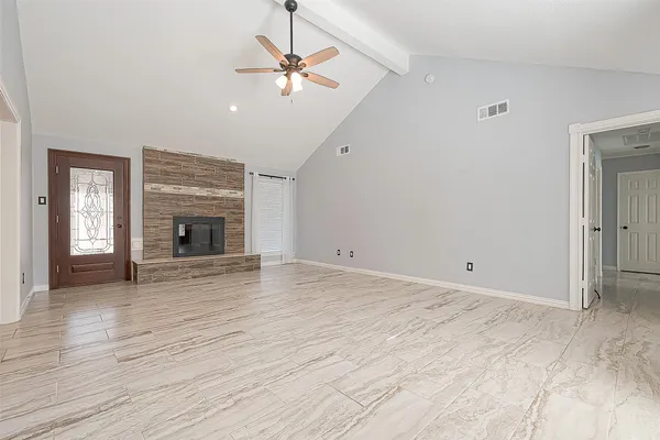a view of an empty room with window and wooden floor