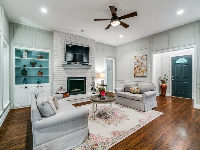 a living room with furniture a flat screen tv and a fireplace