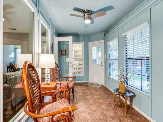 a living room with patio furniture and a large window