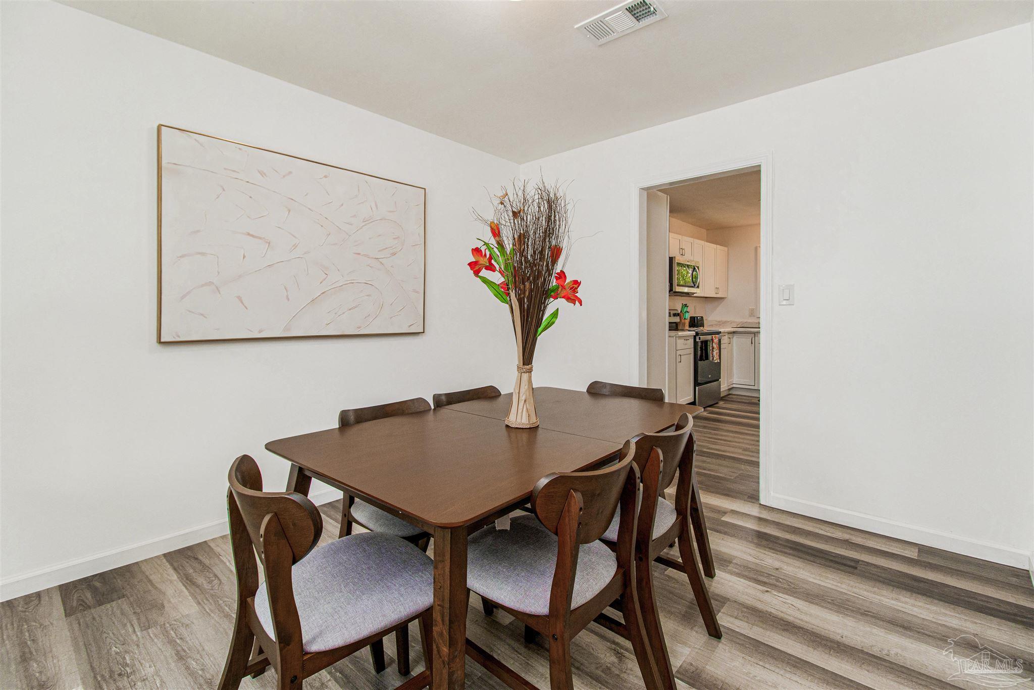 100 Mango Street Pensacola, FL 32503 - Photo 20 of 47 a view of a dining room with furniture and wooden floor
