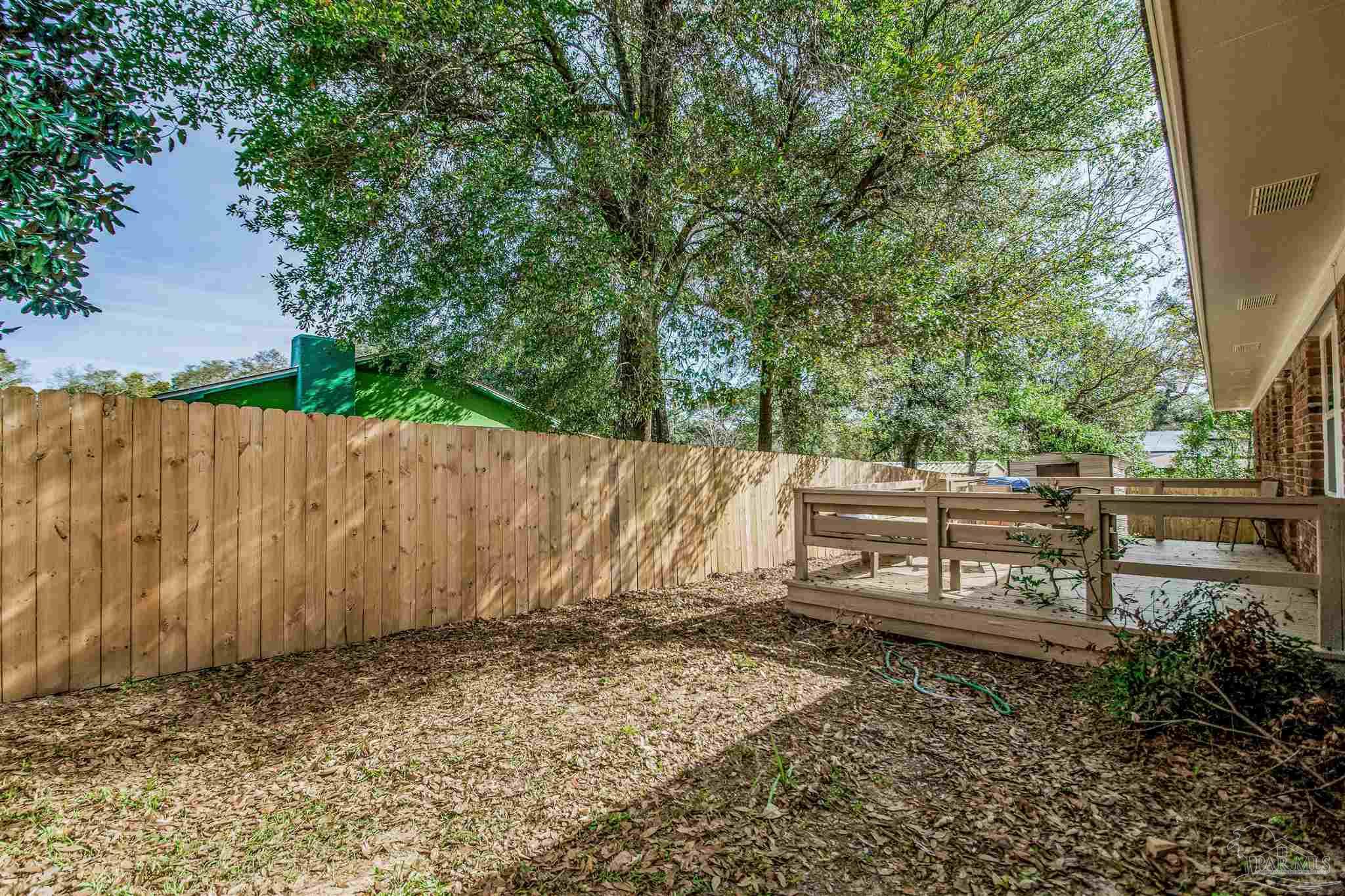 100 Mango Street Pensacola, FL 32503 - Photo 34 of 47 a view of a backyard with plants and wooden fence