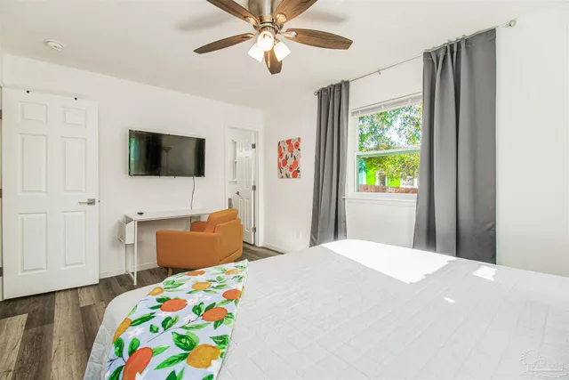 a bedroom with a bed a window and a flat screen tv