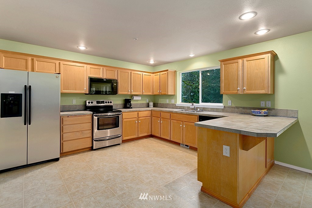 5306 Northeast 11th Court Renton, WA 98059 - Photo 7 of 27 a kitchen with a sink stove and microwave