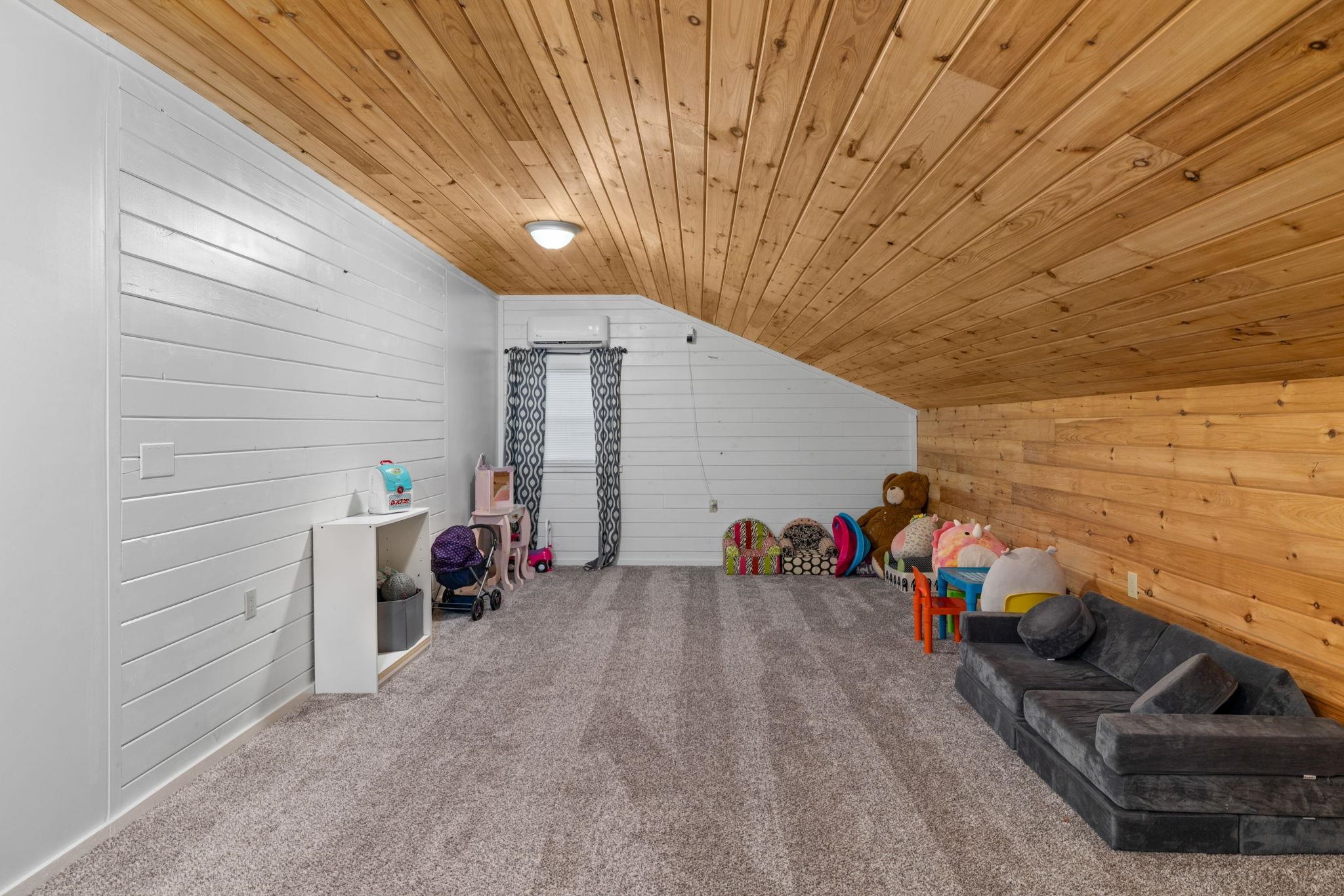 66 County Road 511 Corinth, MS 38834 - Photo 28 of 40 Spacious attic room featuring wood-finish plank ceiling, shiplap-style walls, and gray carpet flooring