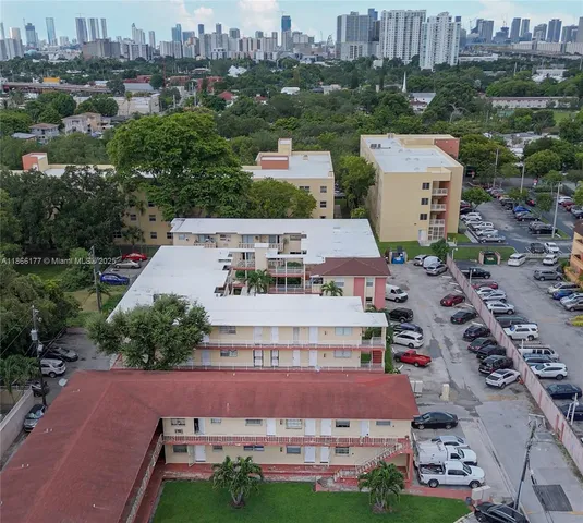an aerial view of residential houses with outdoor space and parking