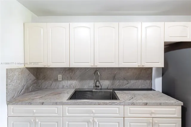 a view of white cabinets and sink