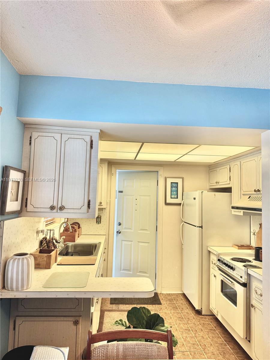 3500 Harrison Street, Unit 7 Hollywood, FL 33021 - Photo 19 of 66 a kitchen with a stove a sink and a refrigerator