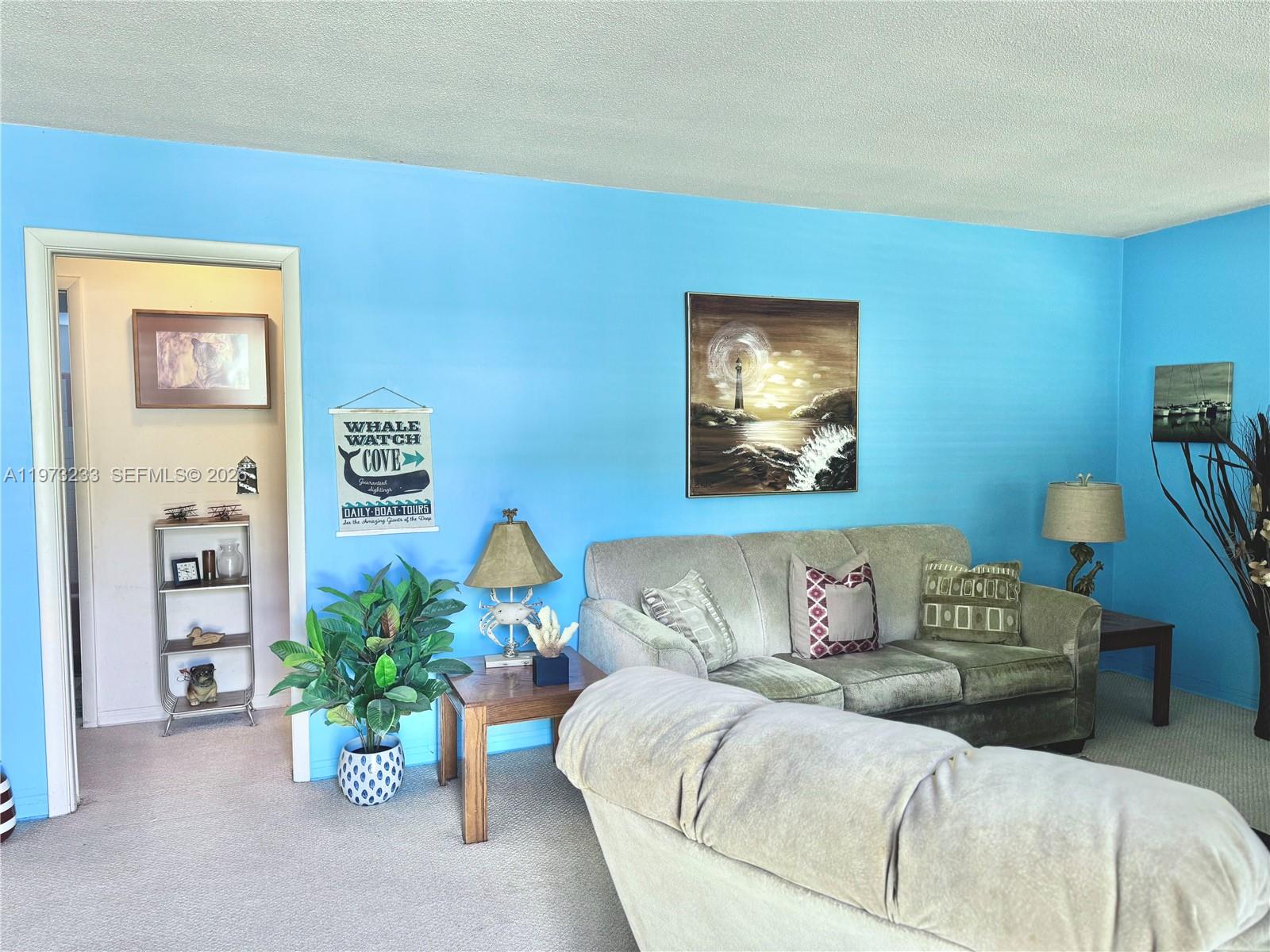 3500 Harrison Street, Unit 7 Hollywood, FL 33021 - Photo 2 of 66 a living room with furniture and flowers