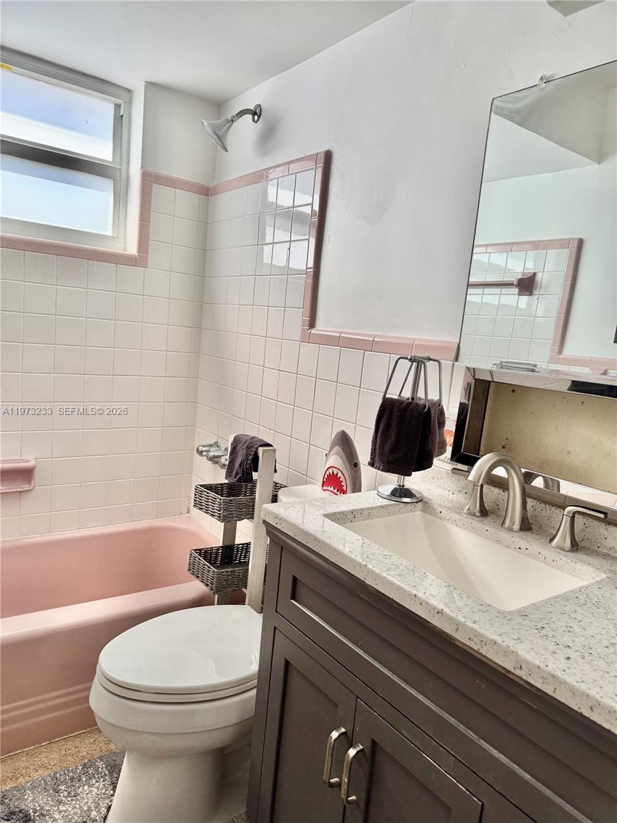 3500 Harrison Street, Unit 7 Hollywood, FL 33021 - Photo 9 of 66 a bathroom with a granite countertop toilet sink and mirror