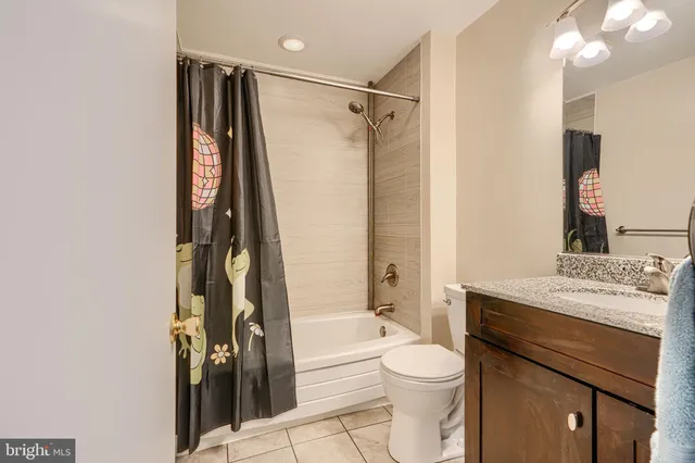 a bathroom with a granite countertop toilet sink and shower