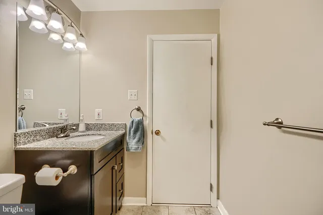 a bathroom with a granite countertop sink and a mirror