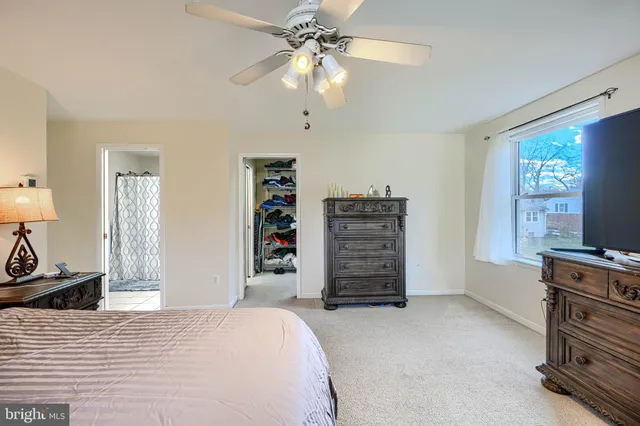a bedroom with a bed dresser and a flat tv screen