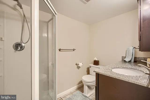a bathroom with a granite countertop sink toilet and shower