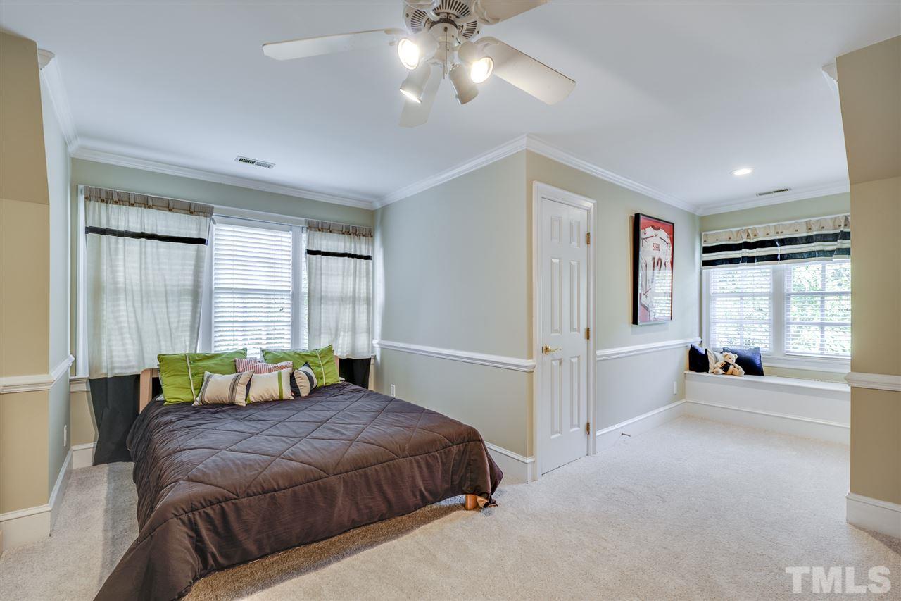 4621 White Chapel Way Raleigh, NC 27615 - Photo 22 of 30 a spacious bedroom with a bed and a chandelier