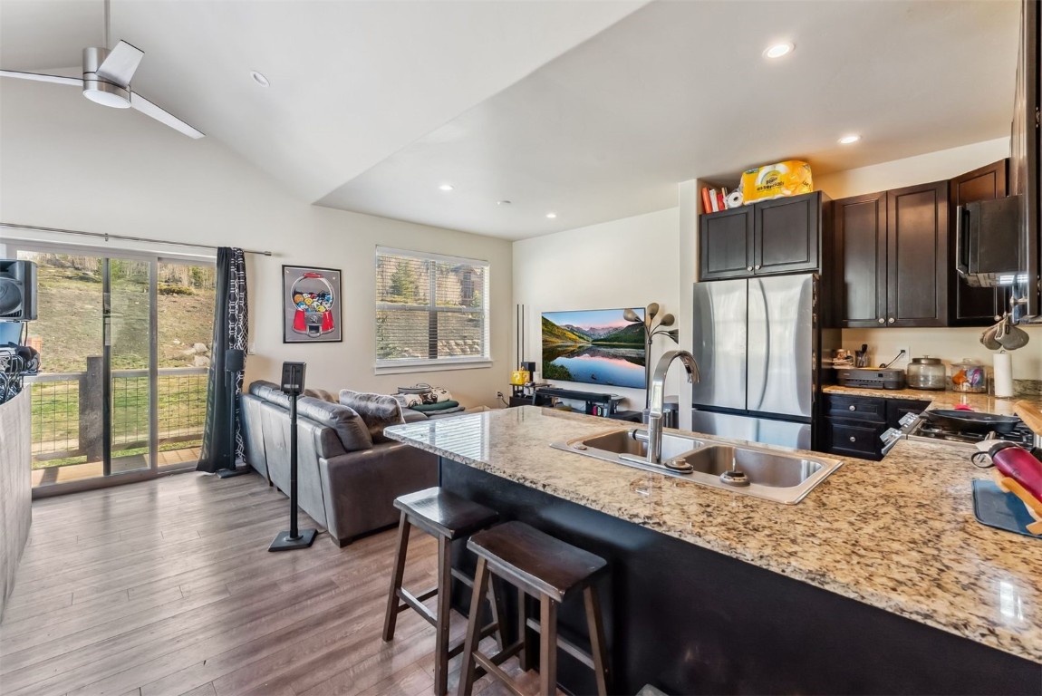 32 Wayback Drive, Unit 32 Keystone, CO 80435 - Photo 9 of 28 a kitchen with granite countertop a table chairs stove refrigerator and wooden floor