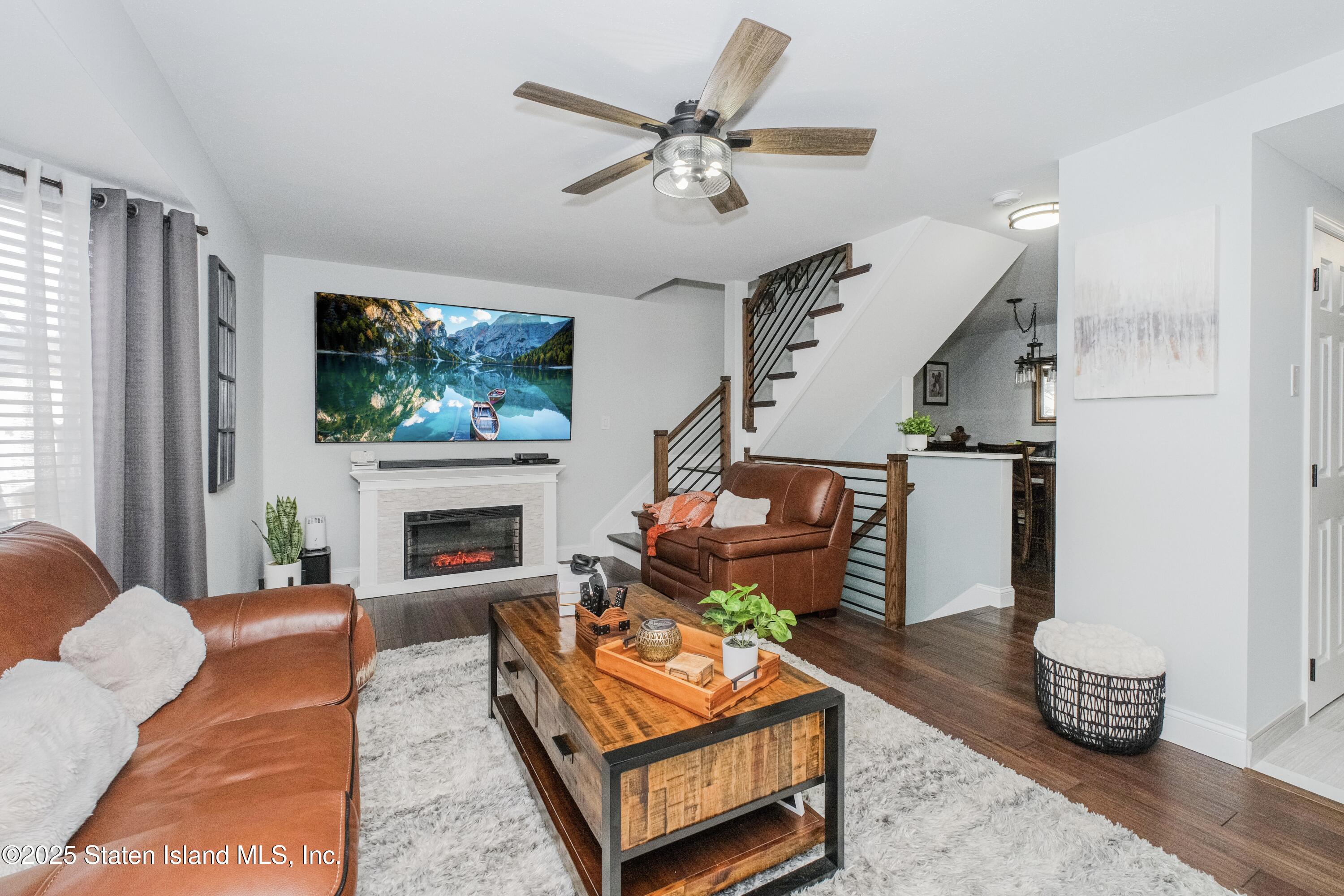 217 Jamie Lane Staten Island, NY 10312 - Photo 11 of 29 a living room with furniture a flat screen tv and a fireplace