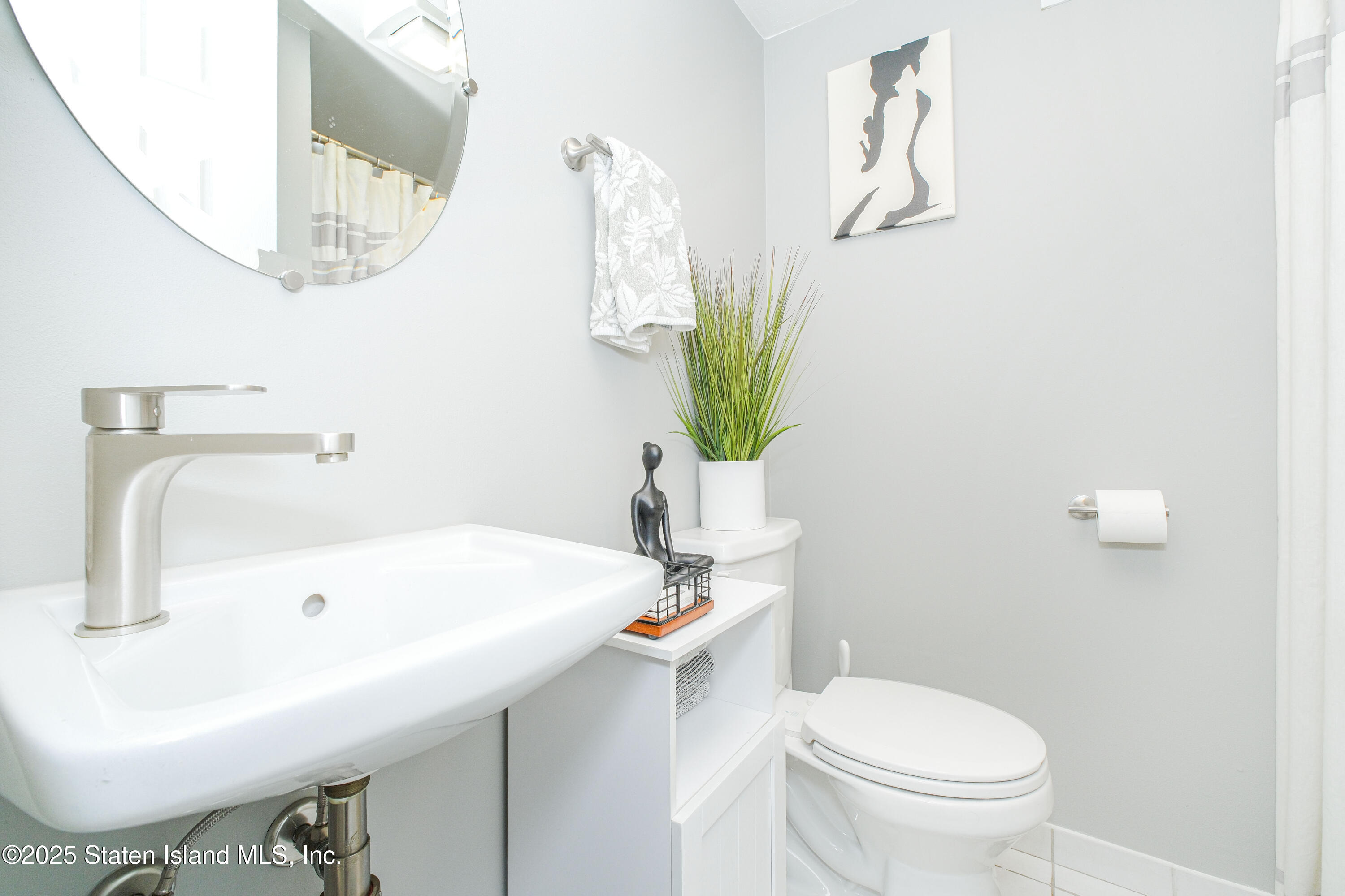 217 Jamie Lane Staten Island, NY 10312 - Photo 7 of 29 a bathroom with a sink a toilet and a mirror