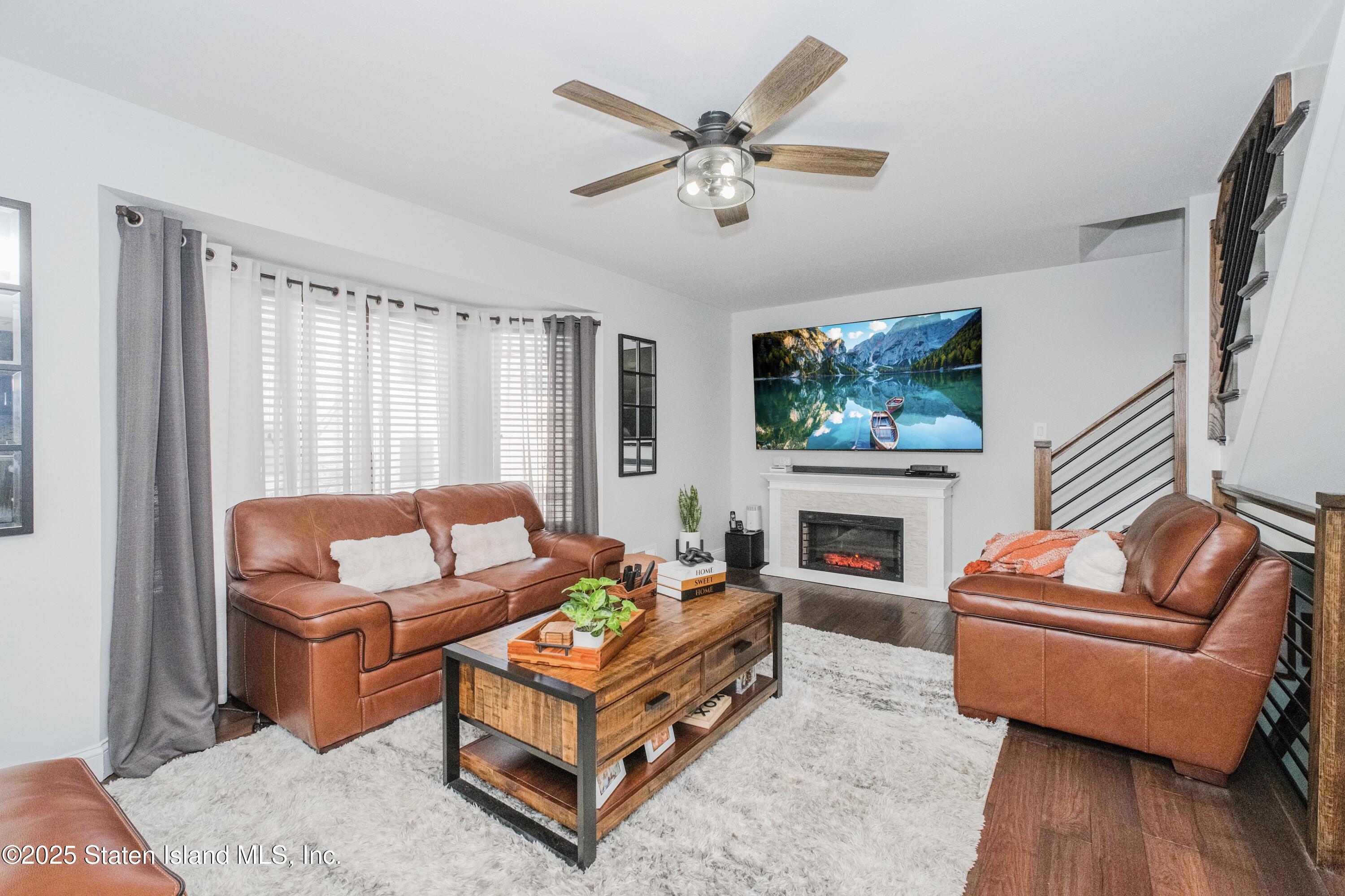 217 Jamie Lane Staten Island, NY 10312 - Photo 10 of 29 a living room with furniture a fireplace and a flat screen tv