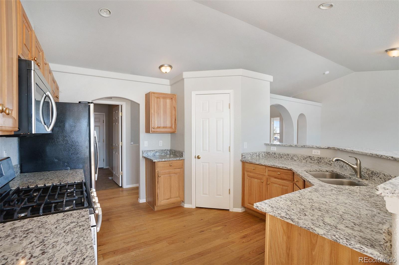 11949 Rio Secco Road Peyton, CO 80831 - Photo 4 of 19 a kitchen with granite countertop a sink stove and refrigerator