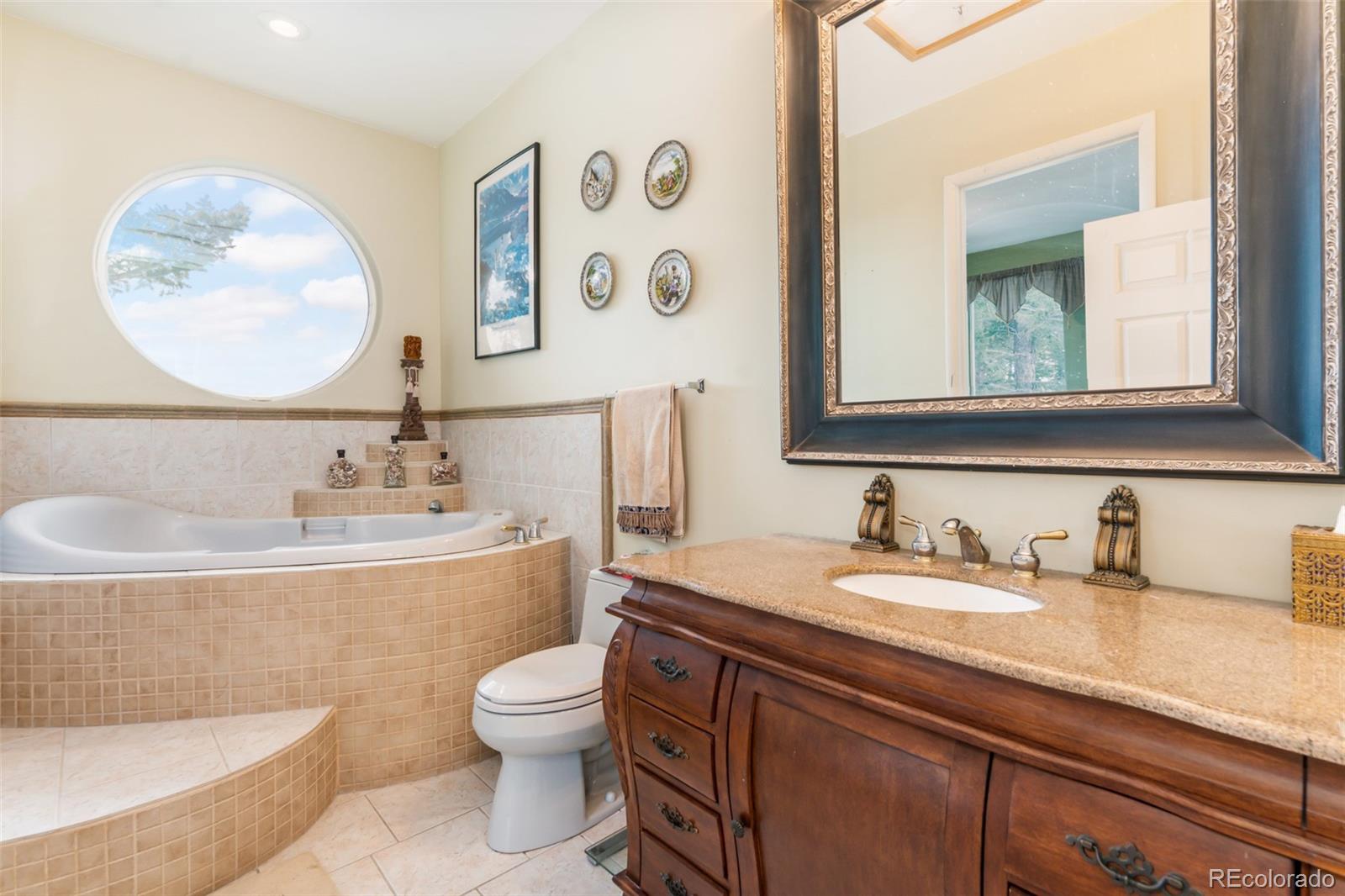 323 Overlook Lane Boulder, CO 80302 - Photo 15 of 40 a bathroom with a granite countertop toilet sink and mirror