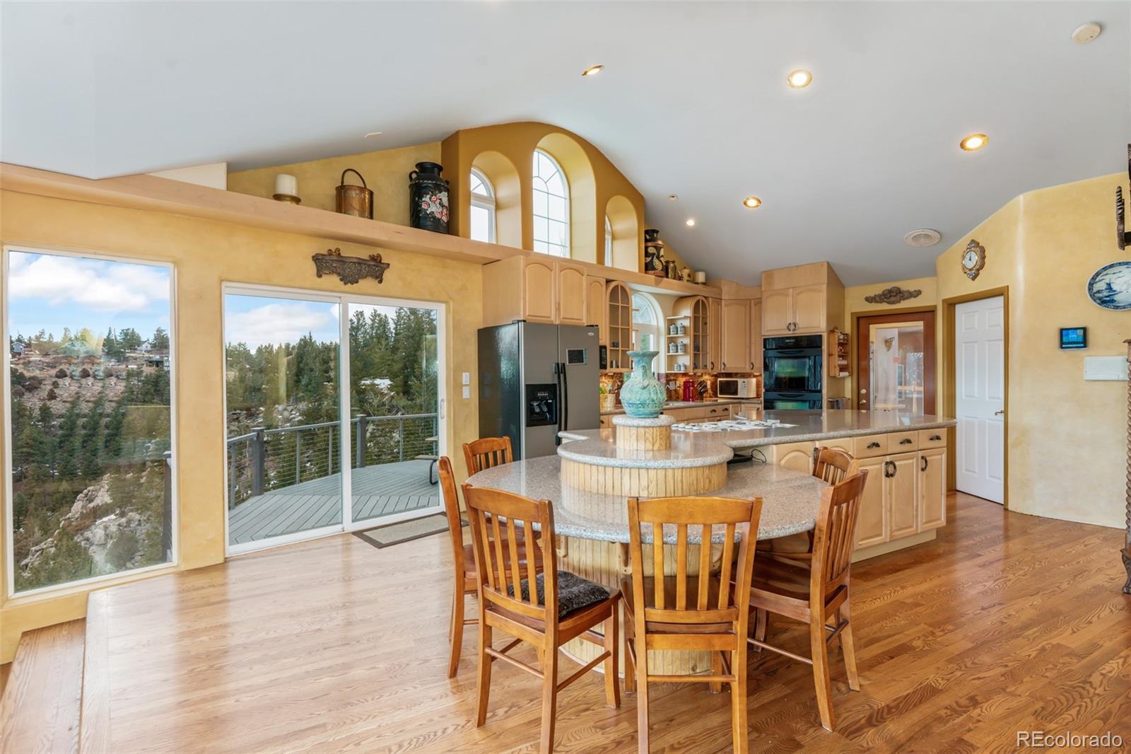 323 Overlook Lane Boulder, CO 80302 - Photo 10 of 40 a kitchen with stainless steel appliances a dining table chairs and wooden floor