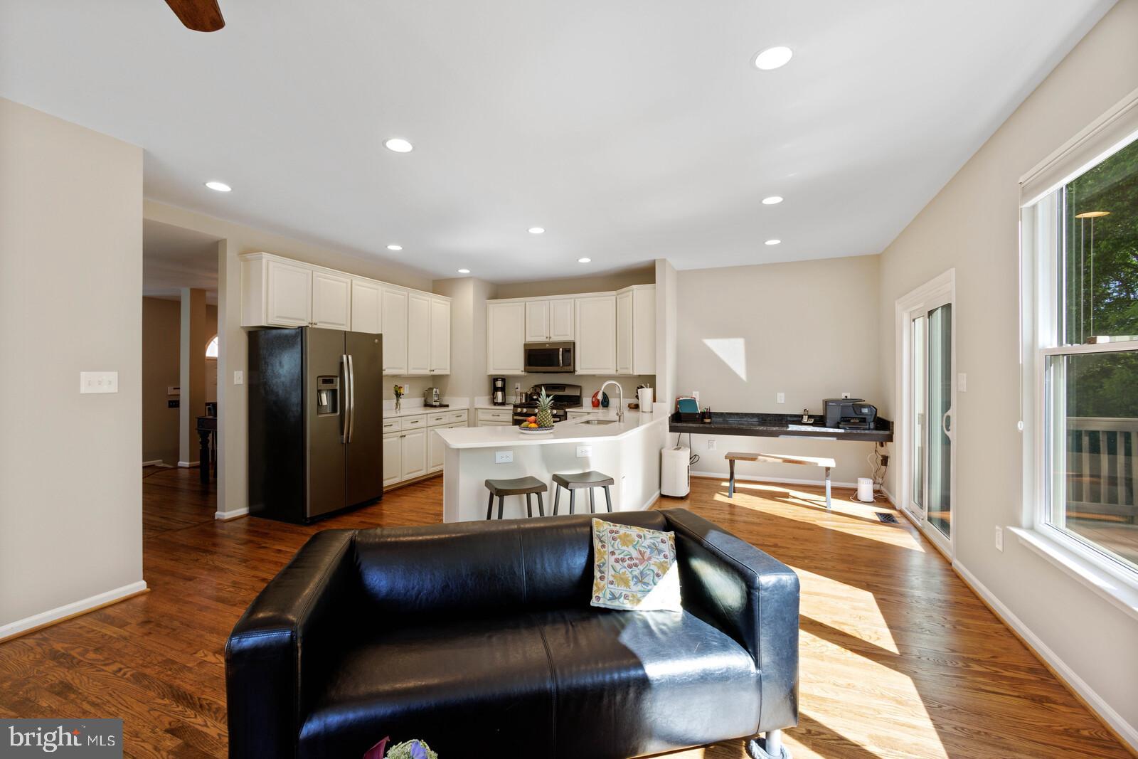 20713 Riptide Square Sterling, VA 20165 - Photo 8 of 65 a kitchen with stainless steel appliances kitchen island granite countertop a refrigerator a stove and a sink with wooden floor