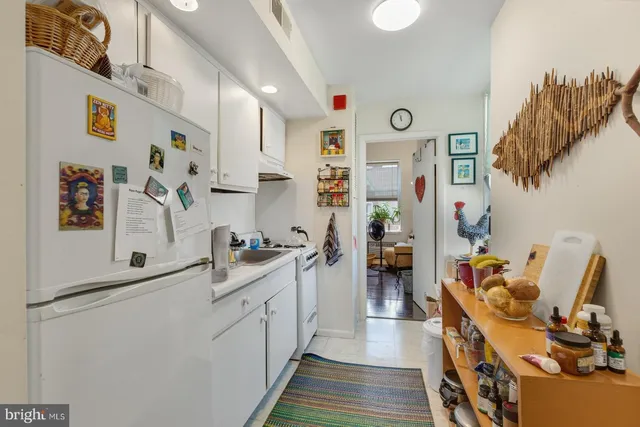 a kitchen with stainless steel appliances a refrigerator and a wooden floor