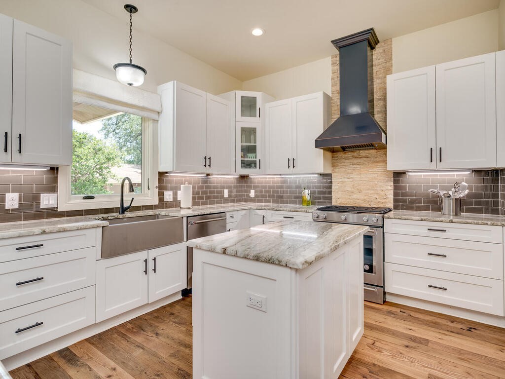 3907 Bailey Lane Austin, TX 78756 - Photo 13 of 37 The contrast of the granite countertops compliment the subway tile backsplash and white, soft-close cabinetry